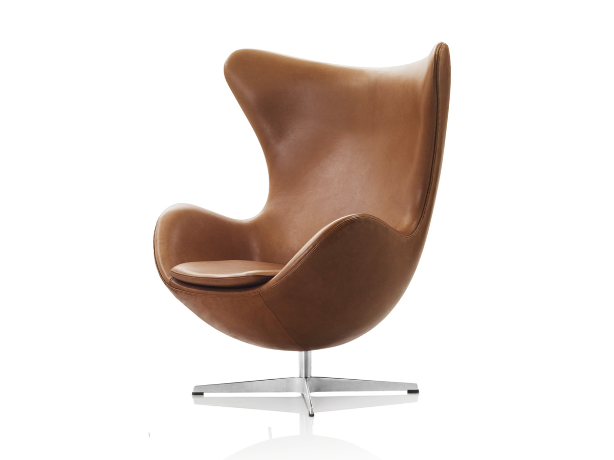 Brown leather curved chair with footrest.