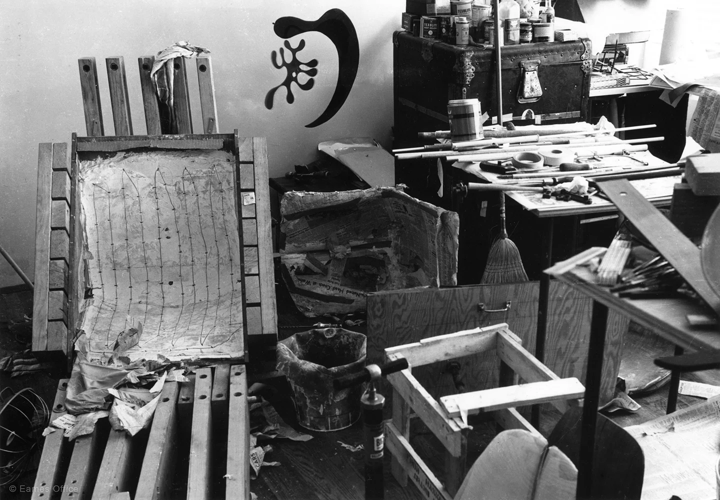 a monochrome image of a cluttered room with various objects scattered around.