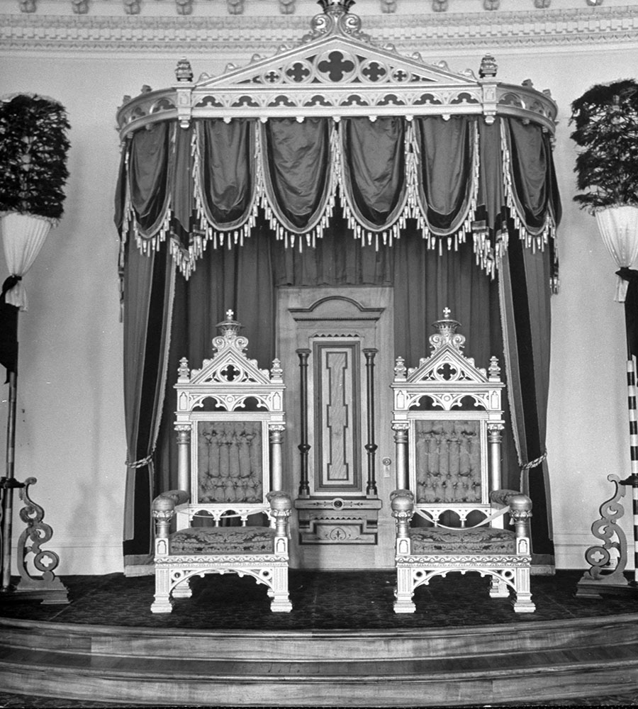black and white image of opulent royal throne surrounded by grandeur in the royal gallery with regal decorations.